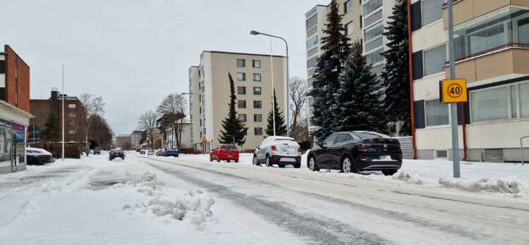 Cars parked by the road on Kalliokatu-street during winter.