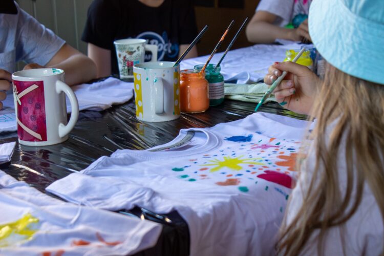 Children painting on t-shirts in Museum camp.