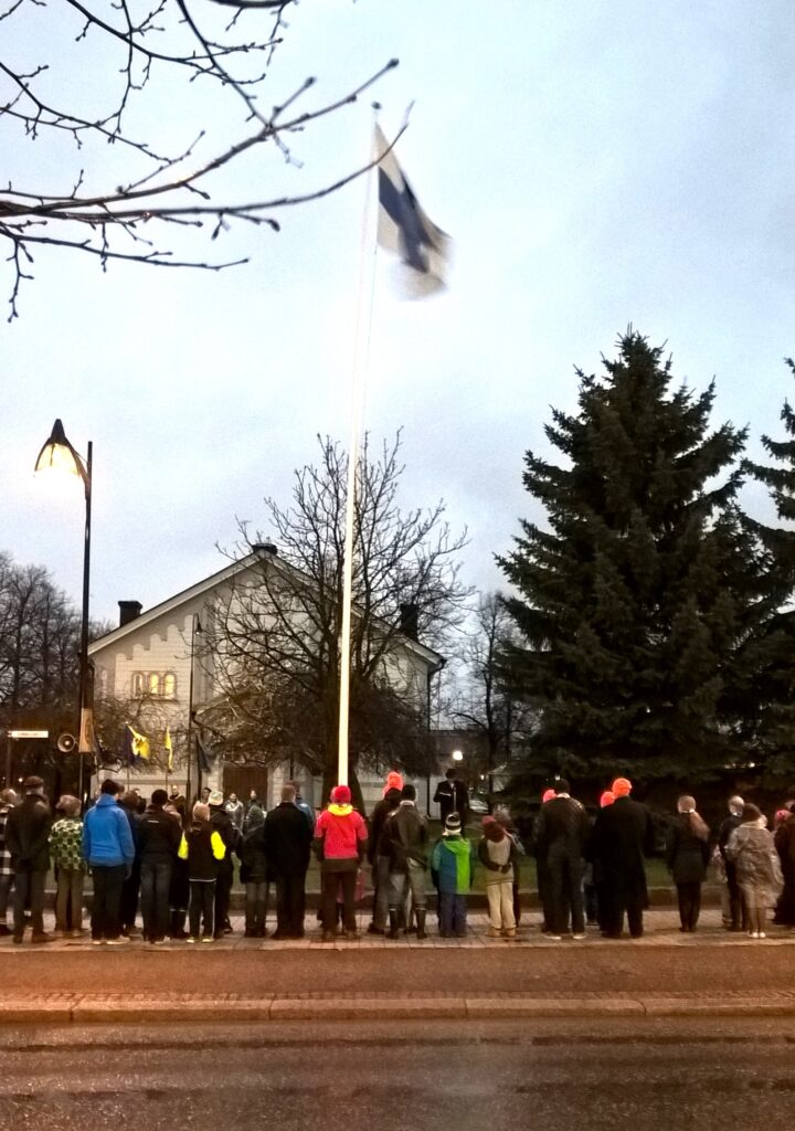 Partiolaiset nostavat lippua Posellin edessä.