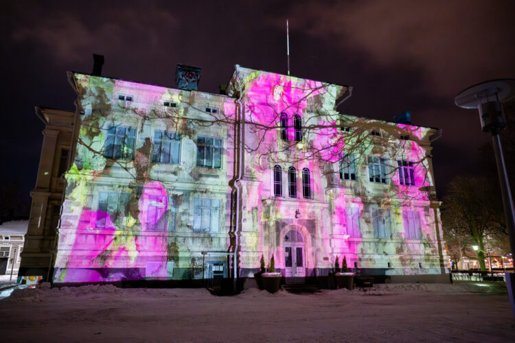 Tarvonsaaren koulun rakennukseen heijastettuna Lumen-valotaidetapahtuman valoteos.